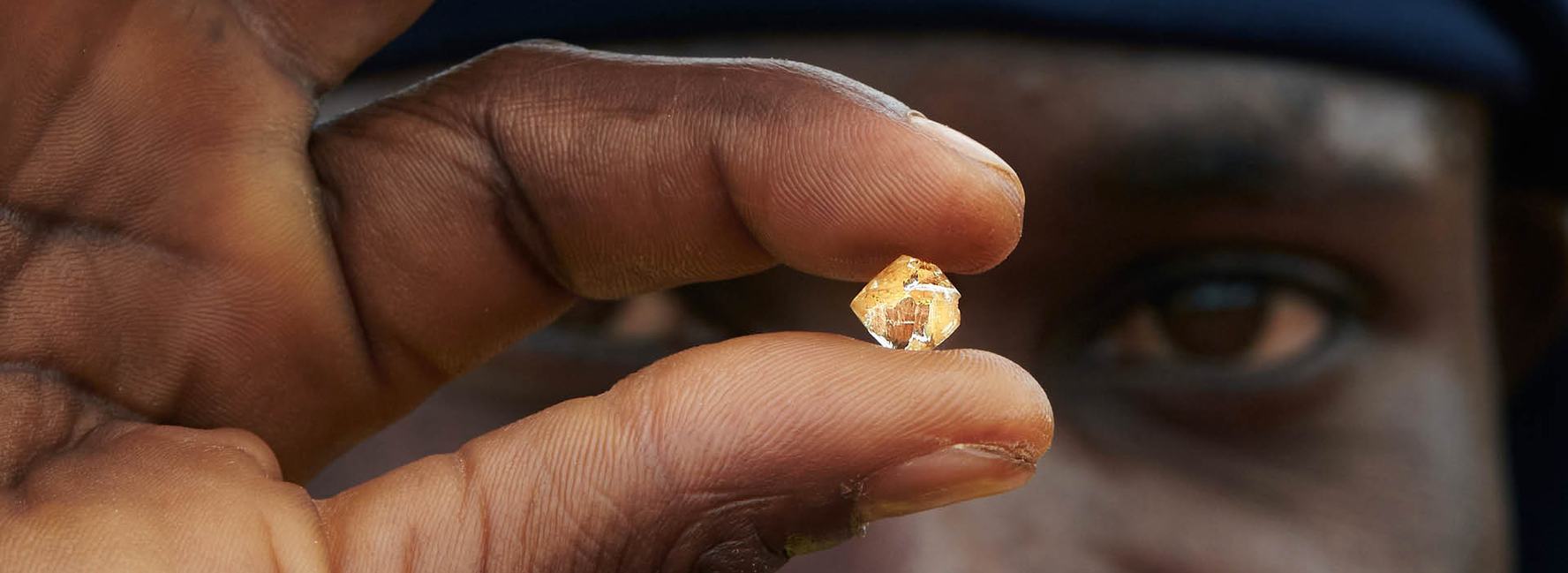 man holding up a mined diamond
